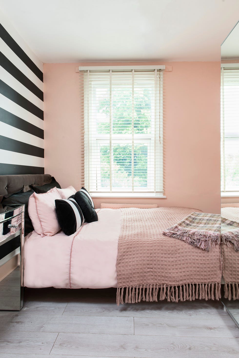 black and pink decorated bedroom black and white stripe wall behind the bed