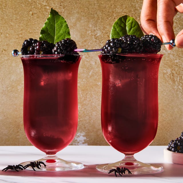 deep red cocktail topped with blackberries and bay leaves