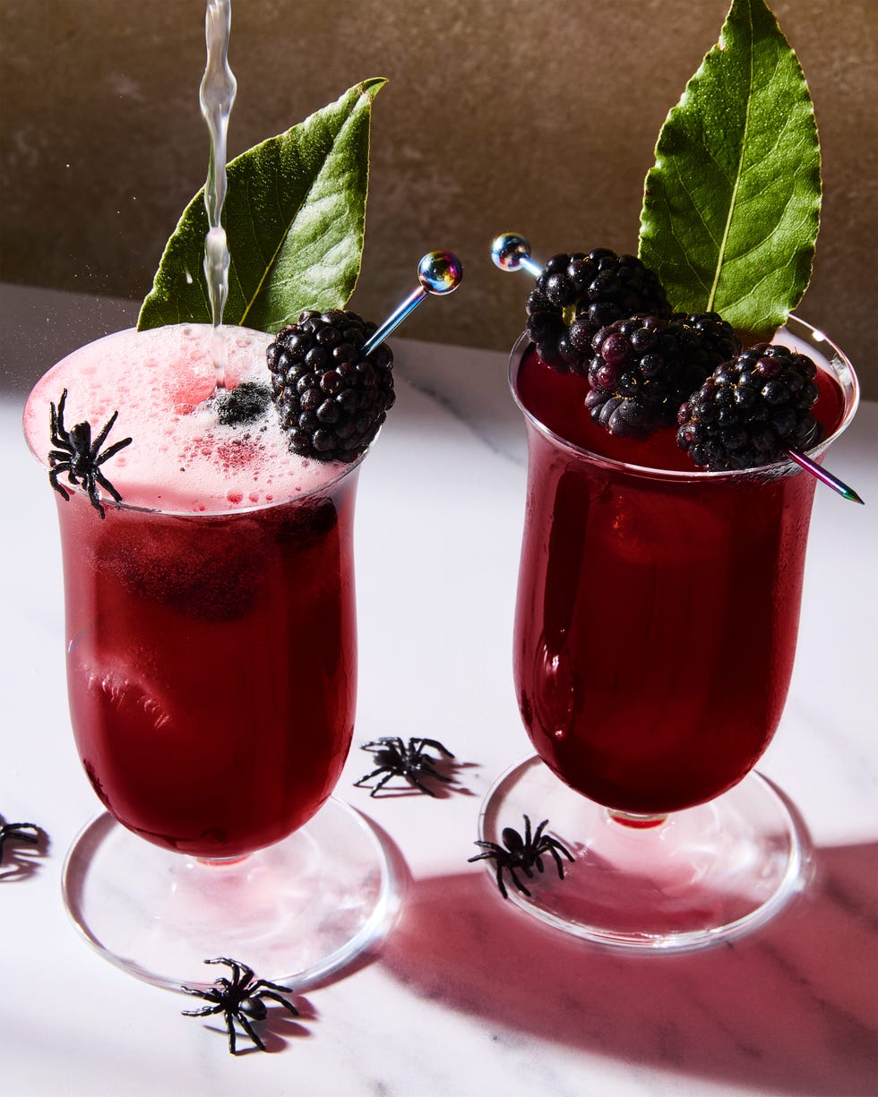 deep red cocktail topped with blackberries and bay leaves