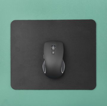 black wireless computer mouse on a green background modern office equipment