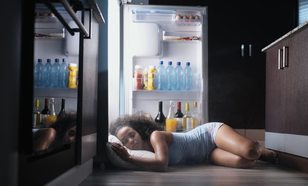 black woman awake for heat wave sleeping in fridge