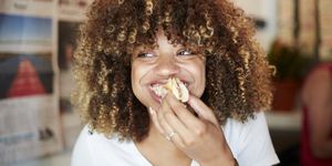 black woman biting sandwich