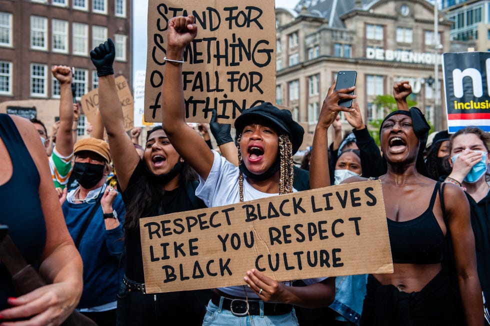 woman holding up sign that reads 'respect black lives like you respect black culture'