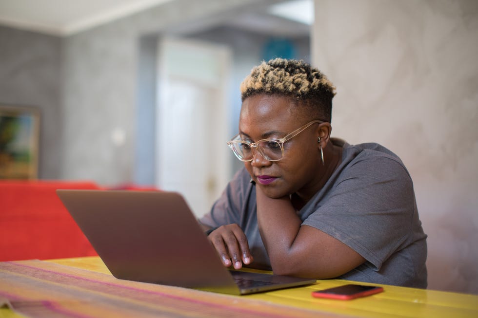 healthy dining out - Black woman looking closely at laptop