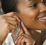 black woman putting on earring