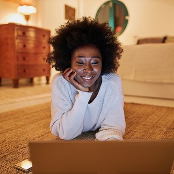 black woman surfing the net on her laptop at home