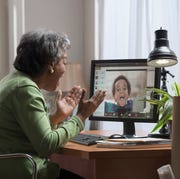 A grandma video chats with her grandson on a computer a grandma video chats with her grandson on a computer