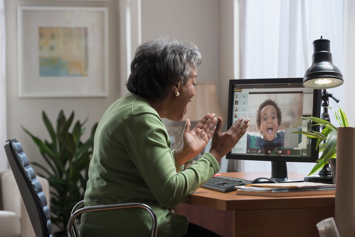a grandma video chats with her grandson on a computer