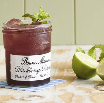a blackberry jam jar with a drink in it and a sprig of mint on top