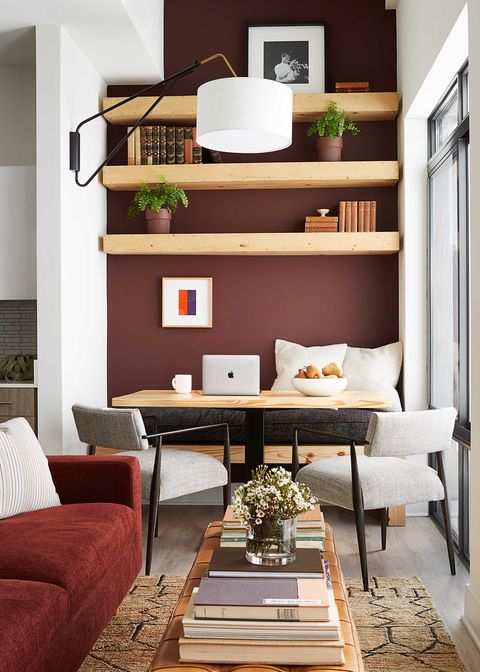 red walls, breakfast nook, wood table, cream chairs, orange couch designed by byron risdon
