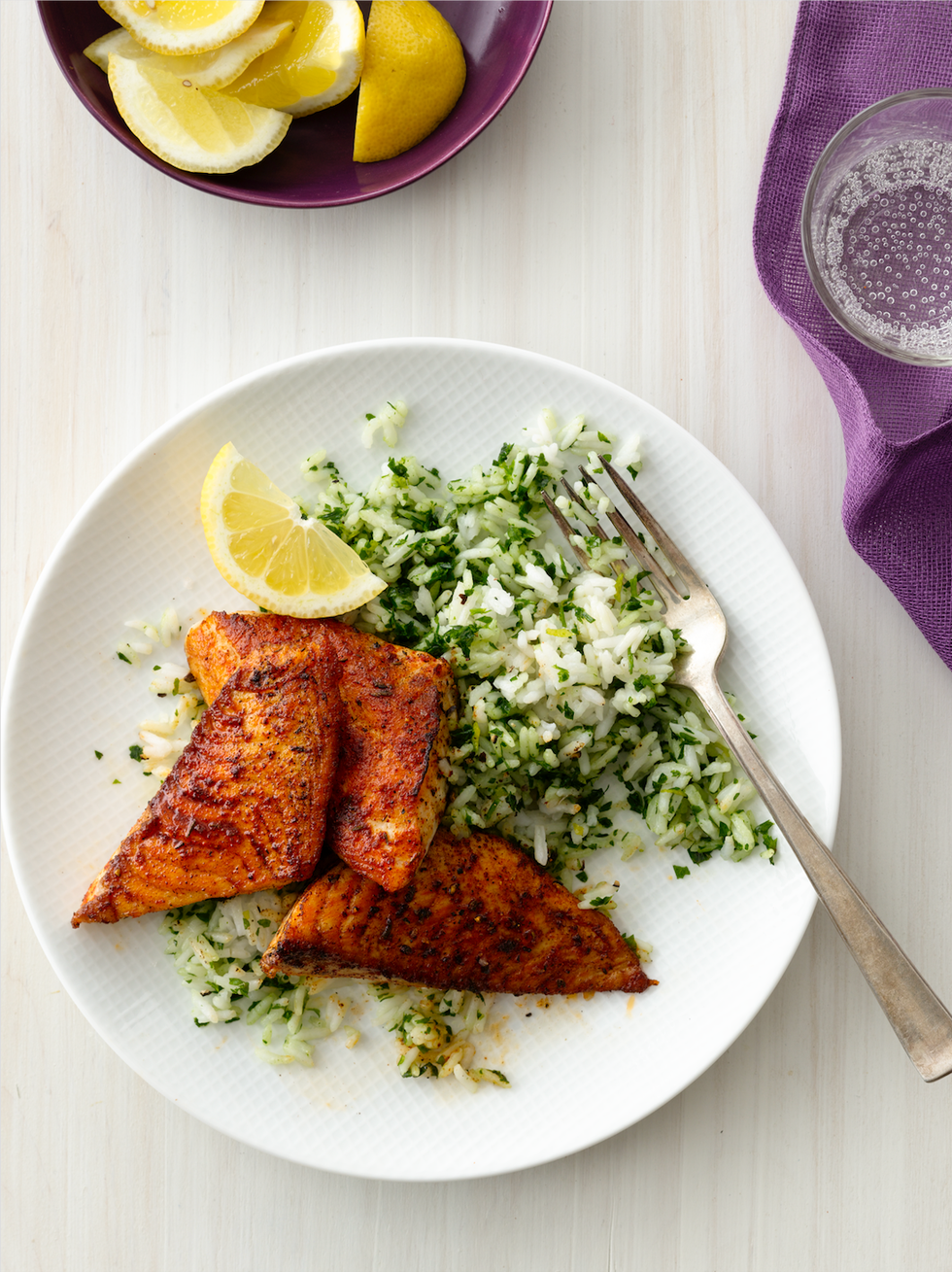 blackened fish with green rice on a plate