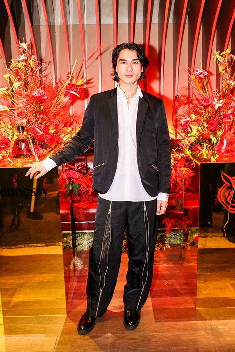 blake abbie wears a black jacket, white button down shirt, and black pants with full length zippers down the front at a lunar new year party in 2023