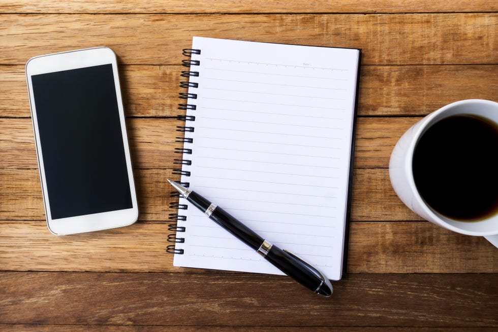 blank white diary with pen, coffee and smart phone