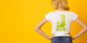 blond girl wearing white t shirt with green eco print, rear view