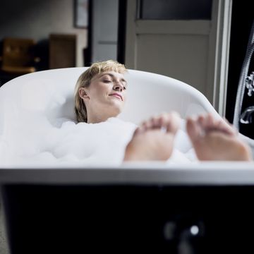 Blond woman taking bubble bath in a loft