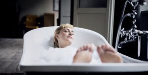 blond woman taking bubble bath in a loft