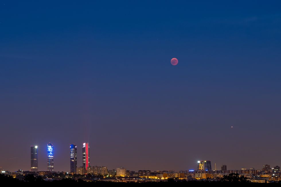 A blood moon over Madrid skyline during a total lunar...