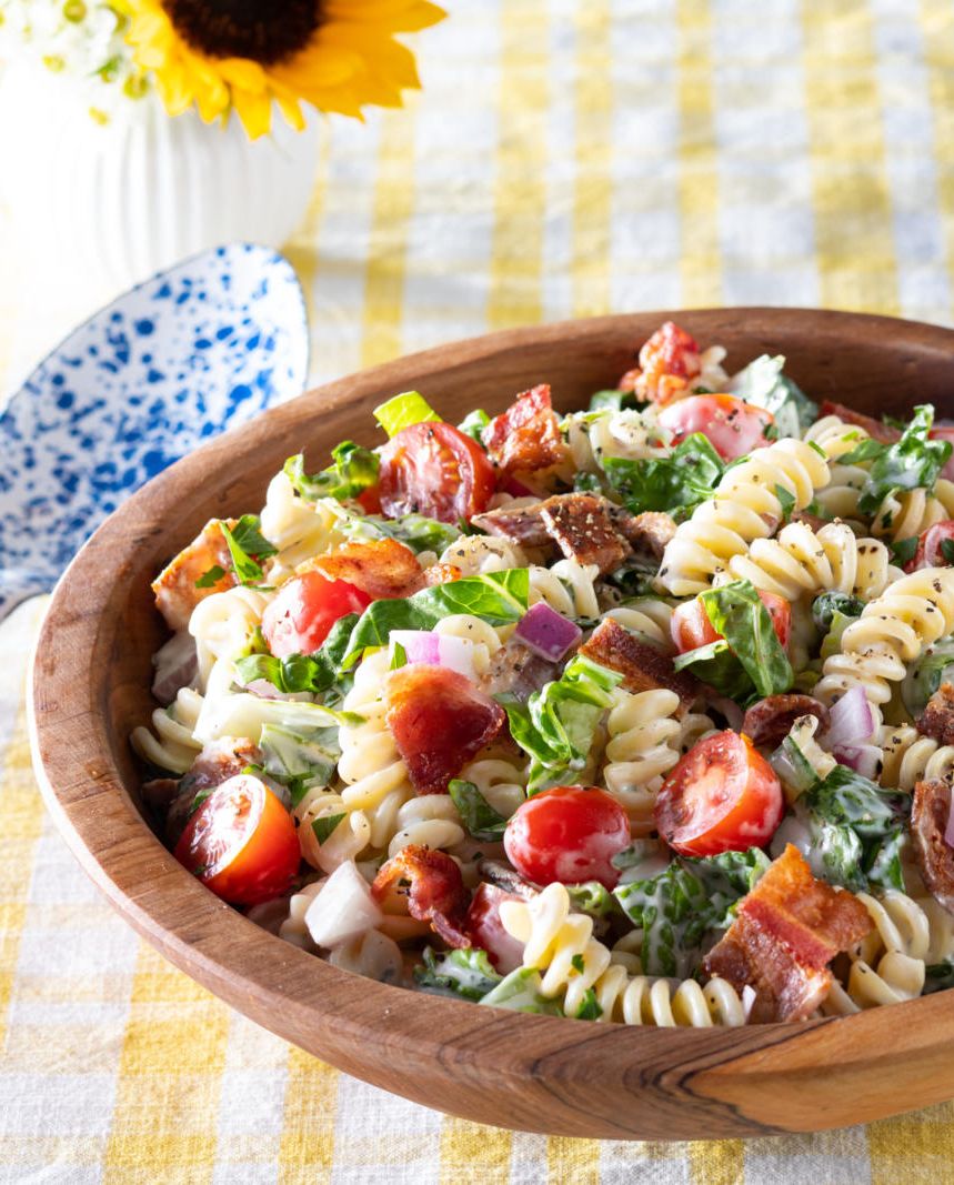 blt pasta salad in wood bowl on yellow linen