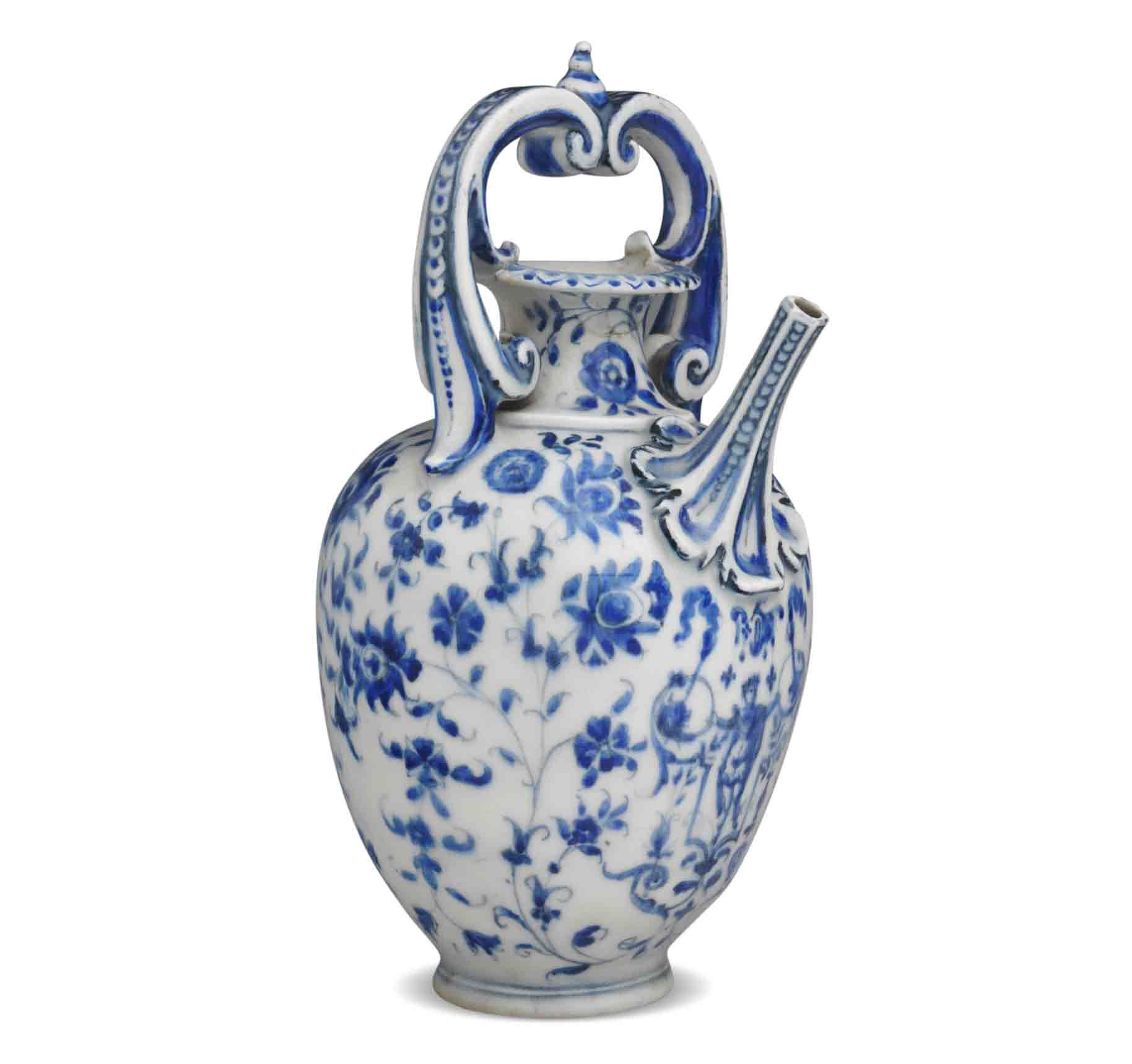 blue and white ceramics in the italian style with an ornamental handle and spout with a floral pattern all over