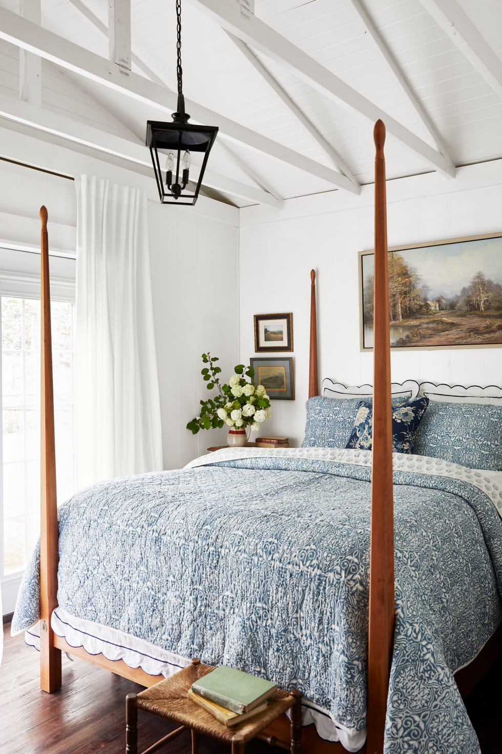 a blue and white bedroom with a wood four poster bed