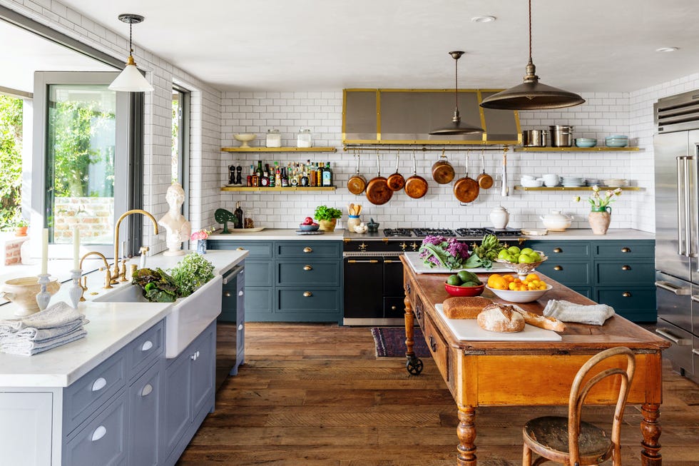 a modern cottage kitchen with blue cabinetry and white tile walls