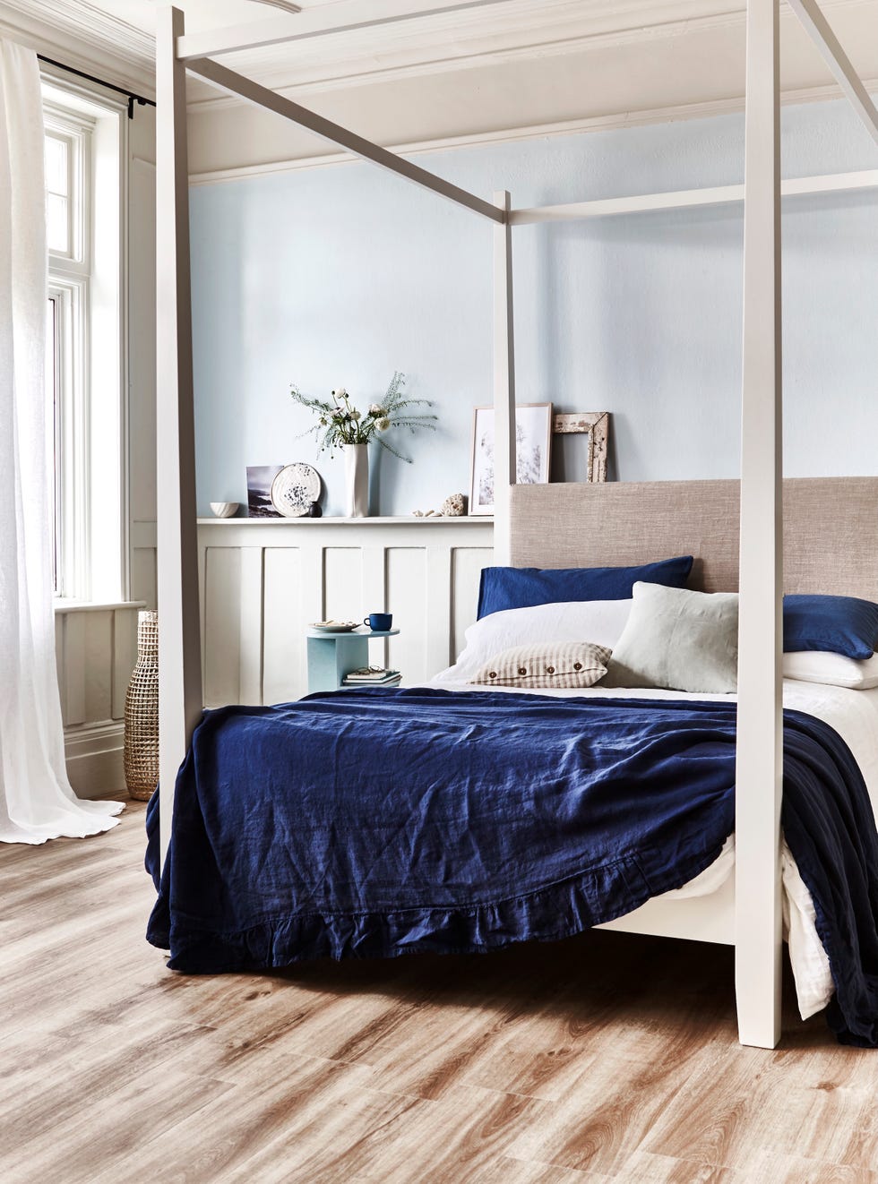 for a bedroom with a touch of beachfront boutique style, opt for a simple, modern four poster bed and layer it up with laid back linens. contemporary luxury vinyl flooring in natural europeanoak, Â£39.99/sq m, house beautiful collection at carpetright. curtain in cellini linen semi sheer, Â£61/m, romo. wavy seagrass basket, Â£79, rose grey. wardley bed, Â£1,260, neptune. ruffle trim bedspread, Â£179.99, zara home. white linen duvet cover, Â£145; white linen pillowcases, Â£23 each; natural stripe cushion, Â£30; light sage cushion, Â£30; all nordic house. blueberry linen pillowcases, Â£36/two, piglet. halves muuto side table, Â£305, nest. sue pryke mug, Â£35; inge vincents vase, Â£140; masako nakagami bowl, Â£88; all maud mabel. ink splatter plate, Â£26, kana london