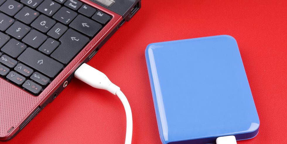 blue external hard drive plugged into red laptop