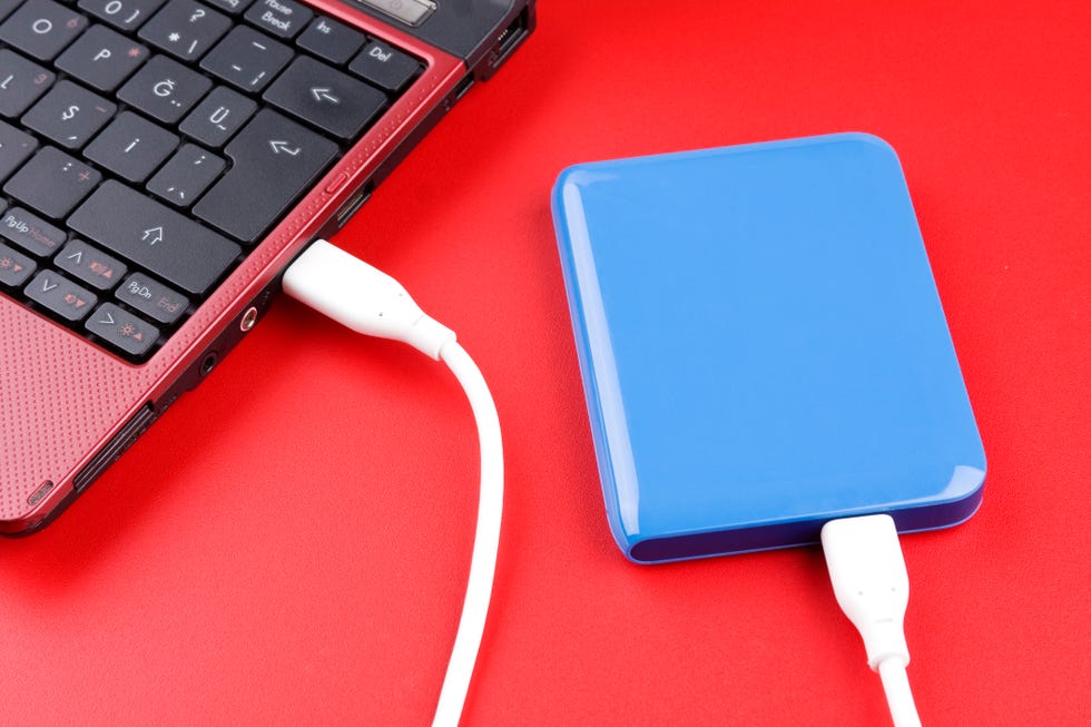 blue external hard drive plugged into red laptop