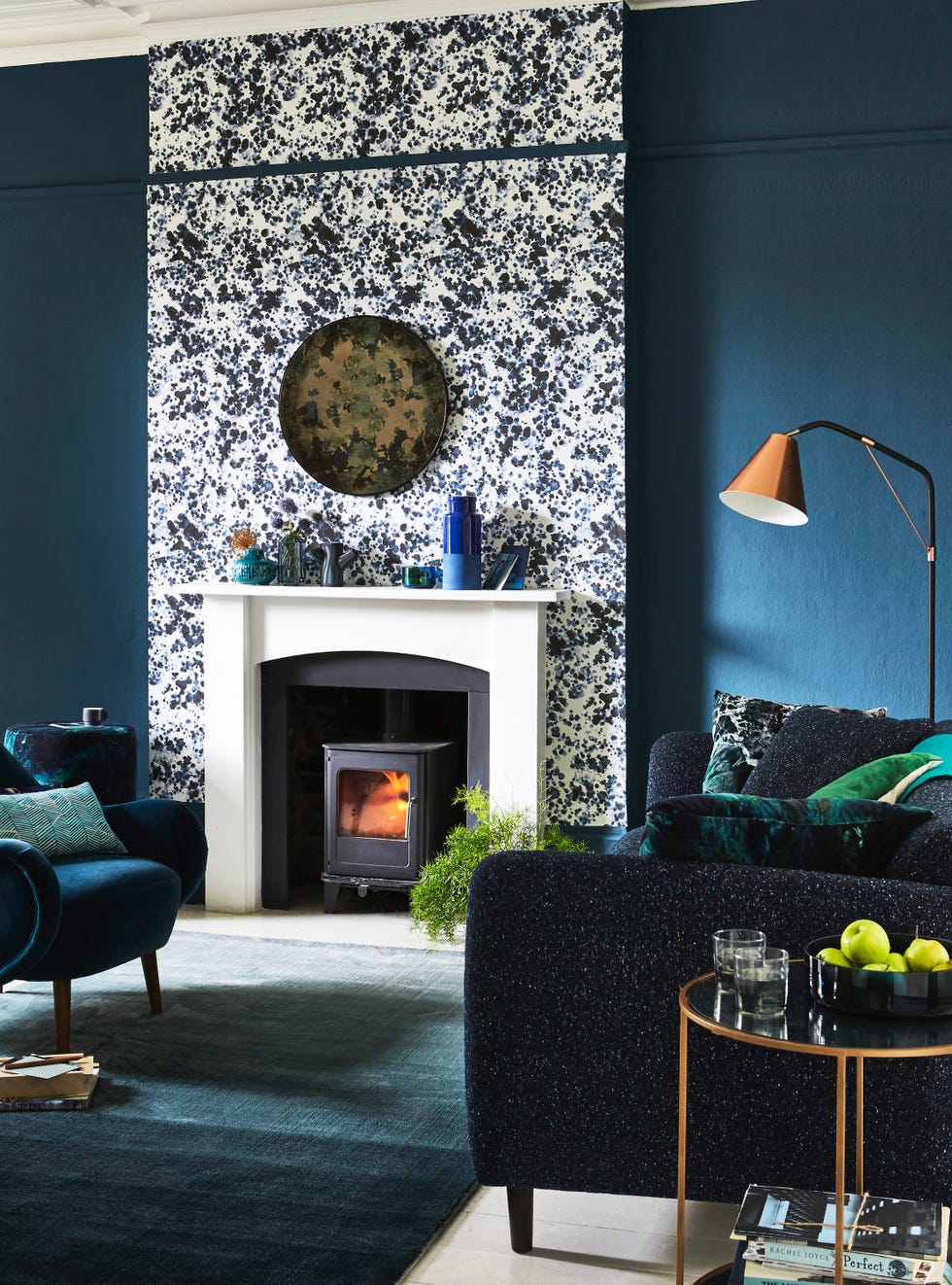 living room of dark green and bluescentrepiece white highlights thechimney breast and fireplace, makingthemthe stars of the show