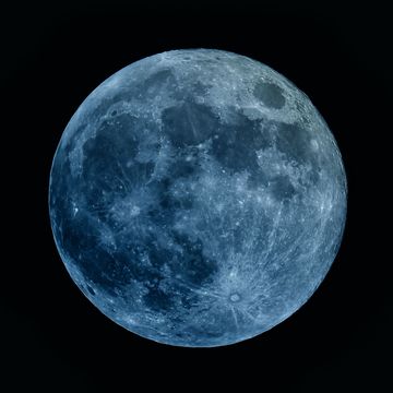 super moon with a blue gray cast in the night sky