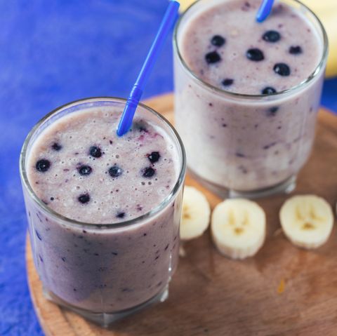 two glass glasses of blueberry smoothie with banana on the table