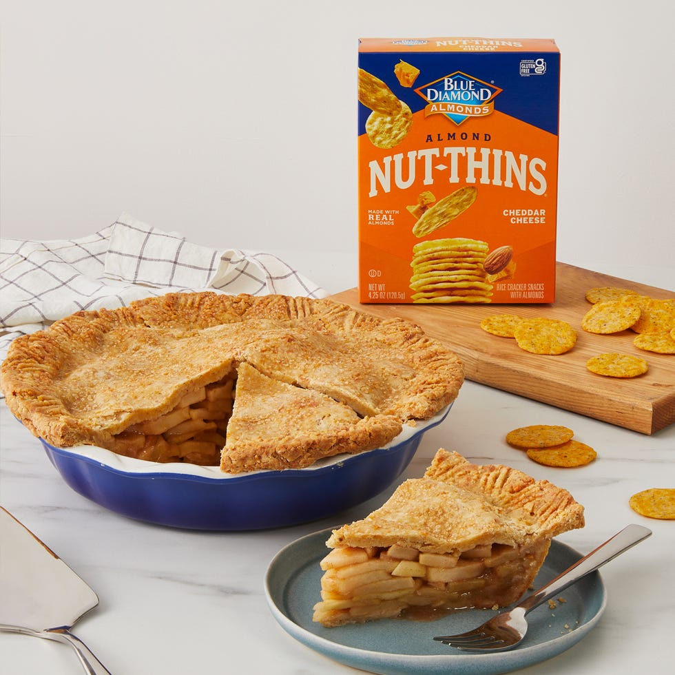 apple pie with a slice cut out accompanied by a box of cheddar cheese crackers and some scattered crackers apple pie with a slice cut out accompanied by a box of cheddar cheese crackers and some scattered crackers