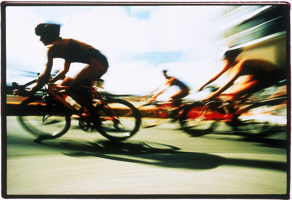 blurred view of triathlon cyclists racing