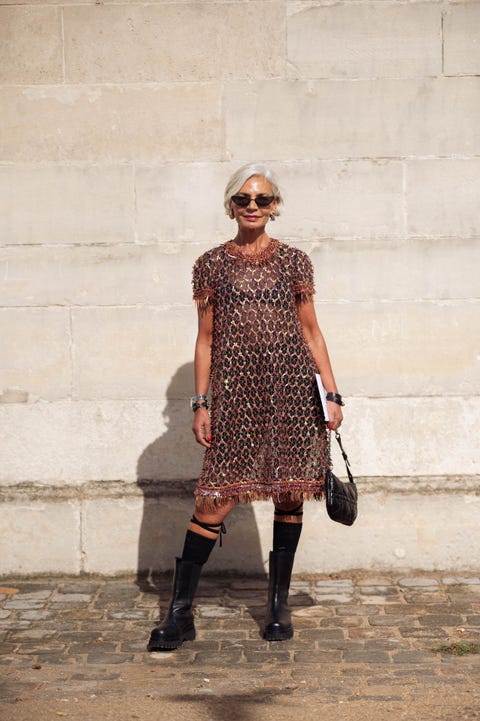 fashionable individual wearing a sheer decorative dress and kneehigh boots