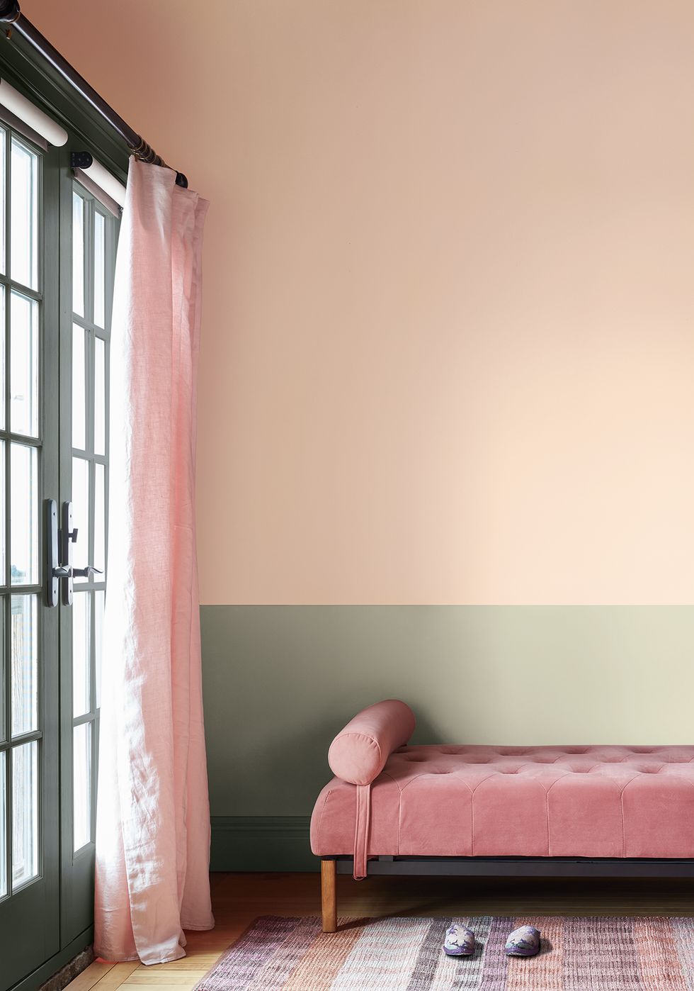 a stylish room featuring a pink velvet chaise lounge with a round cushion on one end