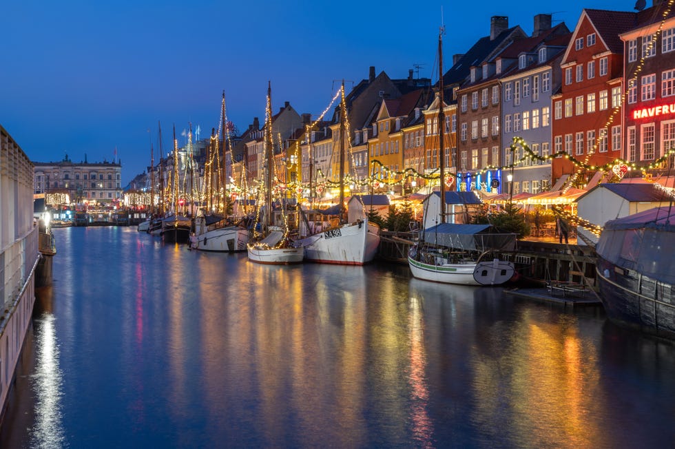 boats and colorful architecture in nyhavn, copenhagen, denmark at dusk