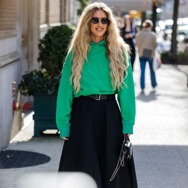 new york, new york february 13 emili sindlev wears green top, navy pleated skirt, prada heels in orange, mini bag outside coach during new york fashion week on february 13, 2023 in new york city photo by christian vieriggetty images