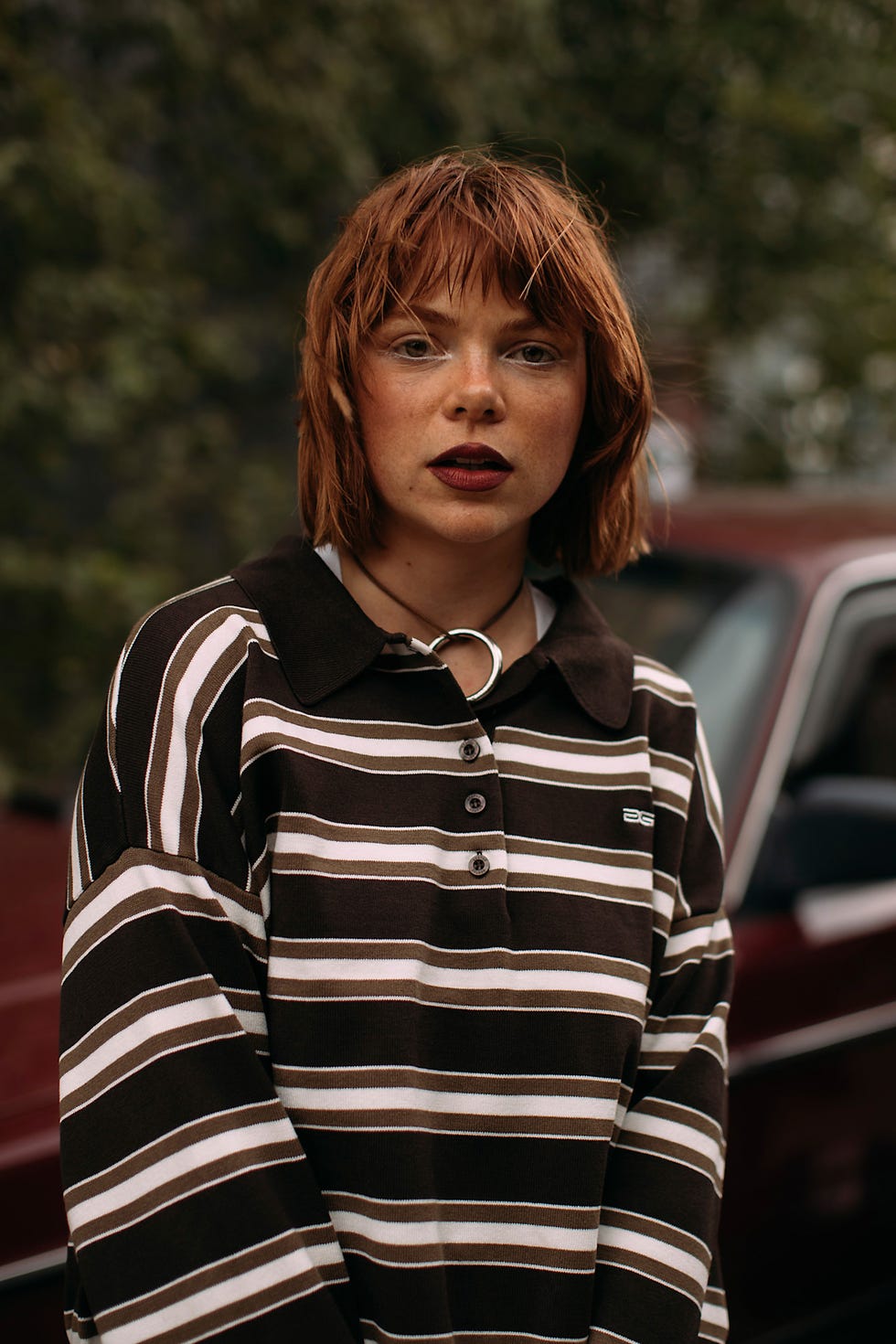 redhead woman wearing a striped longsleeve shirt standing outdoors for bob haircuts copenhagen fashion week