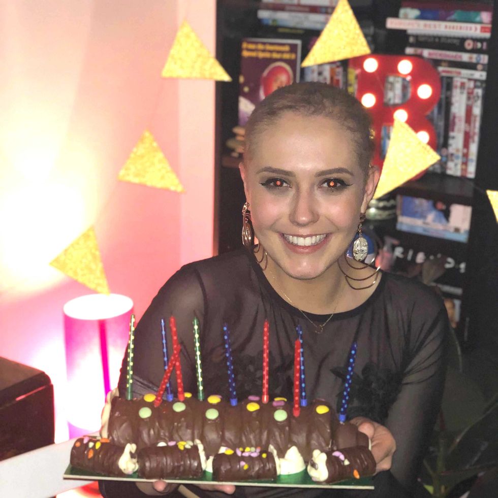 a person smiling with a birthday cake