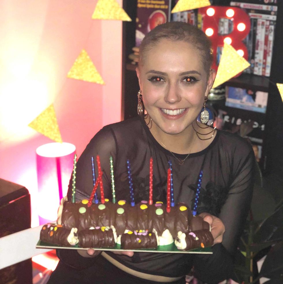 a person smiling with a birthday cake