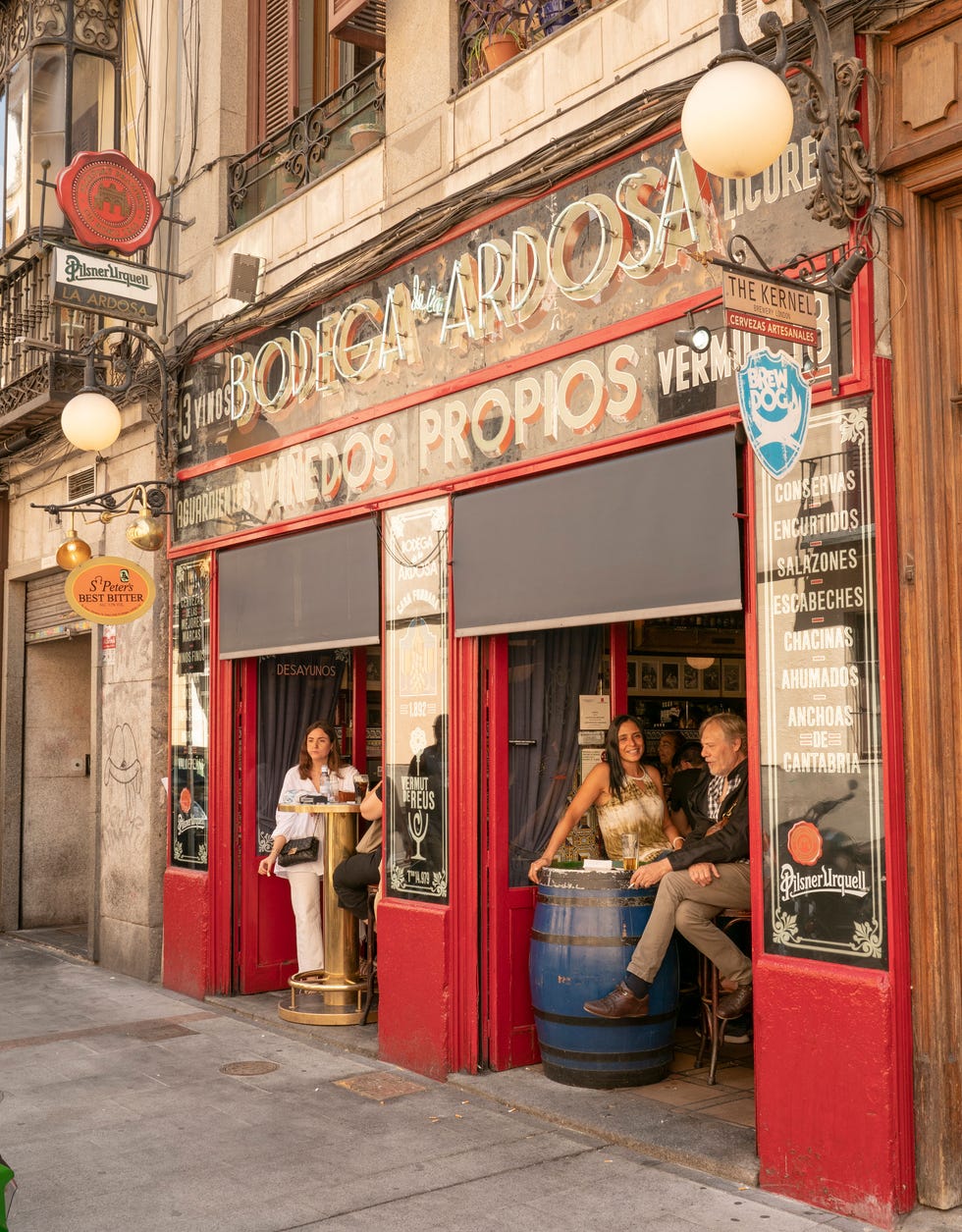 the outside of the bar where a few people can be seen drinking