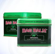 two tins of bag balm in green against blue swirly background
