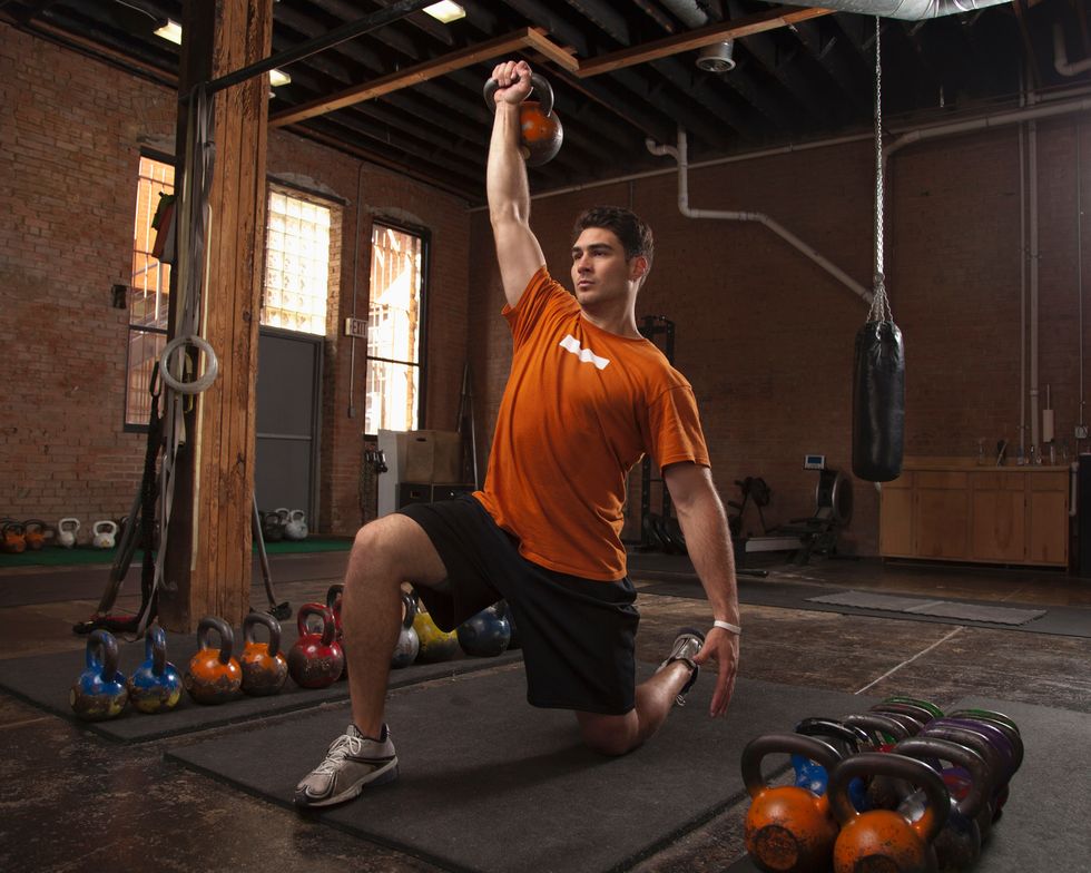 Bodybuilder using kettlebells in gym