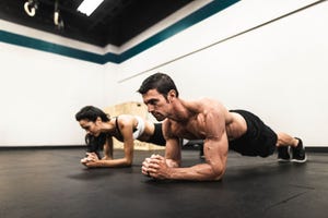 couple of fitness models on the plank position