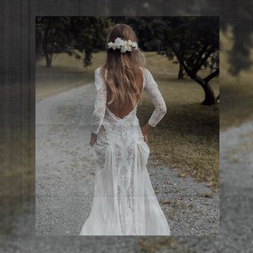 a woman wearing a lace boho wedding dress