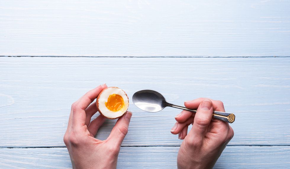 boiled eggs in hands on a wooden background