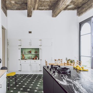 una cocina de campo con vigas de madera y suelo de azulejos verdes