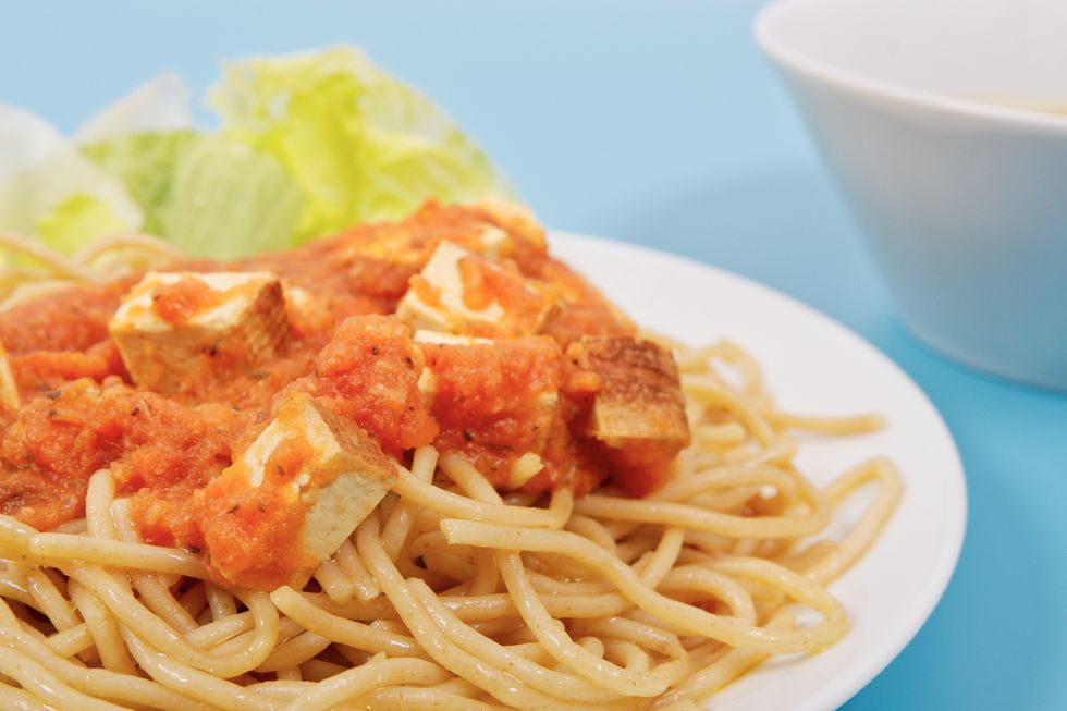 Bolognese spaghetti with tofu on a blue