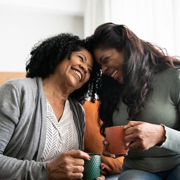 mother and daughter laughing together while having coffee