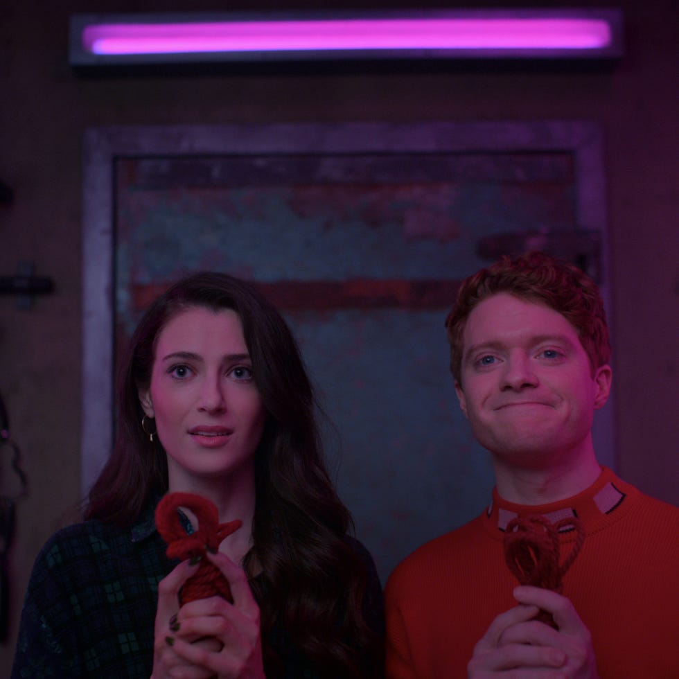 Two individuals holding items set on dark industrial background with soft neon lighting Two individuals holding items set on dark industrial background with soft neon lighting